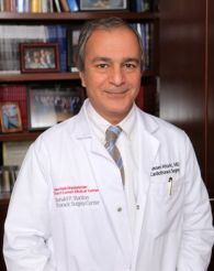 a man in a white coat smiling